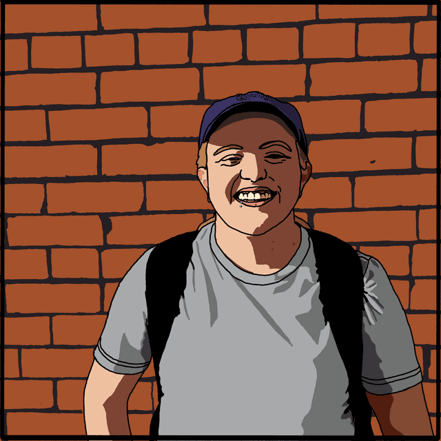 Holly standing in front of a brick wall with an open smile