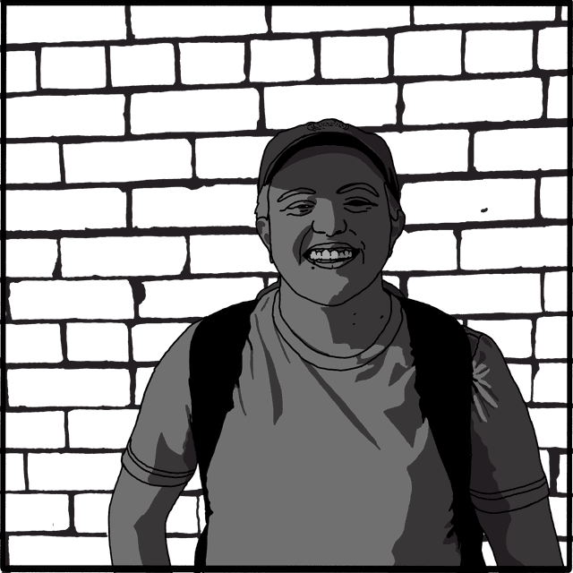 Holly standing in front of a brick wall with an open smile